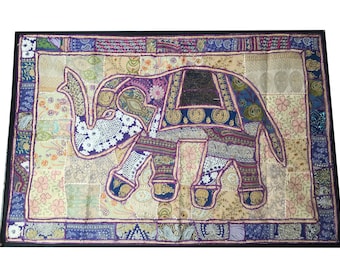 May include: A colorful patchwork elephant wall hanging with purple, blue, and gold accents. The elephant is made of various fabrics and is decorated with sequins and embroidery.