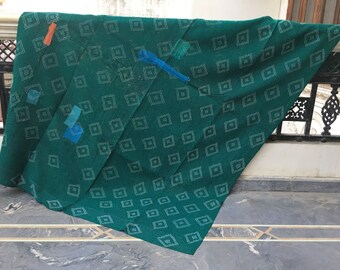 Könnte beinhalten: Eine grüne Kantha-Steppdecke mit einem weißen Rautenmuster. Die Decke wurde mit blauem und orangefarbenem Stoff geflickt.
