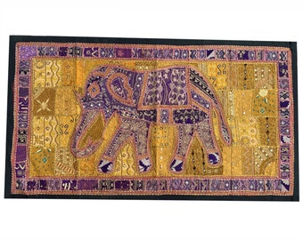 May include: A purple embroidered elephant on a gold and purple patchwork fabric background. The elephant is surrounded by a border of purple and gold fabric.