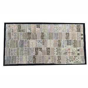 May include: A rectangular patchwork throw pillow with a black border. The pillow is made of various fabrics in shades of brown, beige, and white, with intricate floral patterns and embroidery.