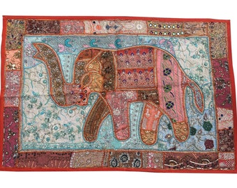 May include: A colorful patchwork elephant wall hanging with intricate embroidery and beaded details. The elephant is made of various fabrics in shades of pink, blue, green, and brown. The background is a red fabric with a border of smaller patchwork squares.