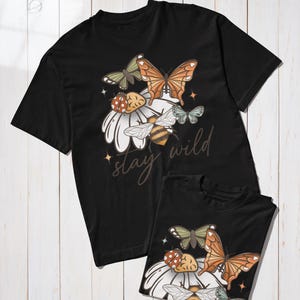 May include: Black t-shirts with a floral and insect design. The design includes butterflies, a bee, and a ladybug on a white daisy. The text "stay wild" is written in a script font.