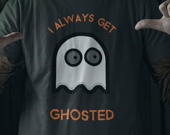 May include: A person wearing a dark green t-shirt with a white ghost graphic and the text "I always get ghosted".
