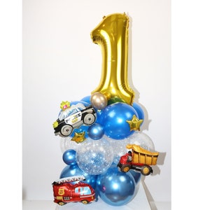 Może przedstawiać: Złoty balon z numerem jeden z niebieskimi i przezroczystymi balonami, balonem z samochodem policyjnym, balonem z wozem strażackim i balonem z wywrotką.