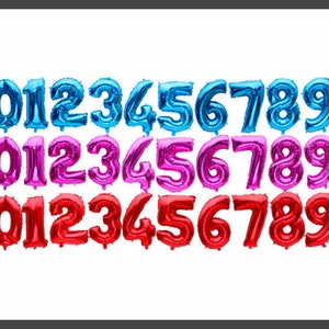 May include: Three sets of foil number balloons, each set in a different color: blue, pink, and red. The numbers range from 0 to 9.