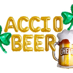 Può includere: Palloncini a forma di lettere dorate in lamina che compongono la scritta "ACCIO BEER" con due palloncini a forma di trifoglio verde e un palloncino a forma di boccale di birra dorato con la scritta "CHEERS" sopra.