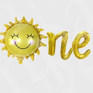 May include: Gold foil balloons spelling "one" with a smiling sun balloon. The sun balloon has pink cheeks and eyelashes.