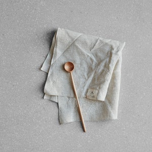 natural coloured linen napkin with a wooden spoon