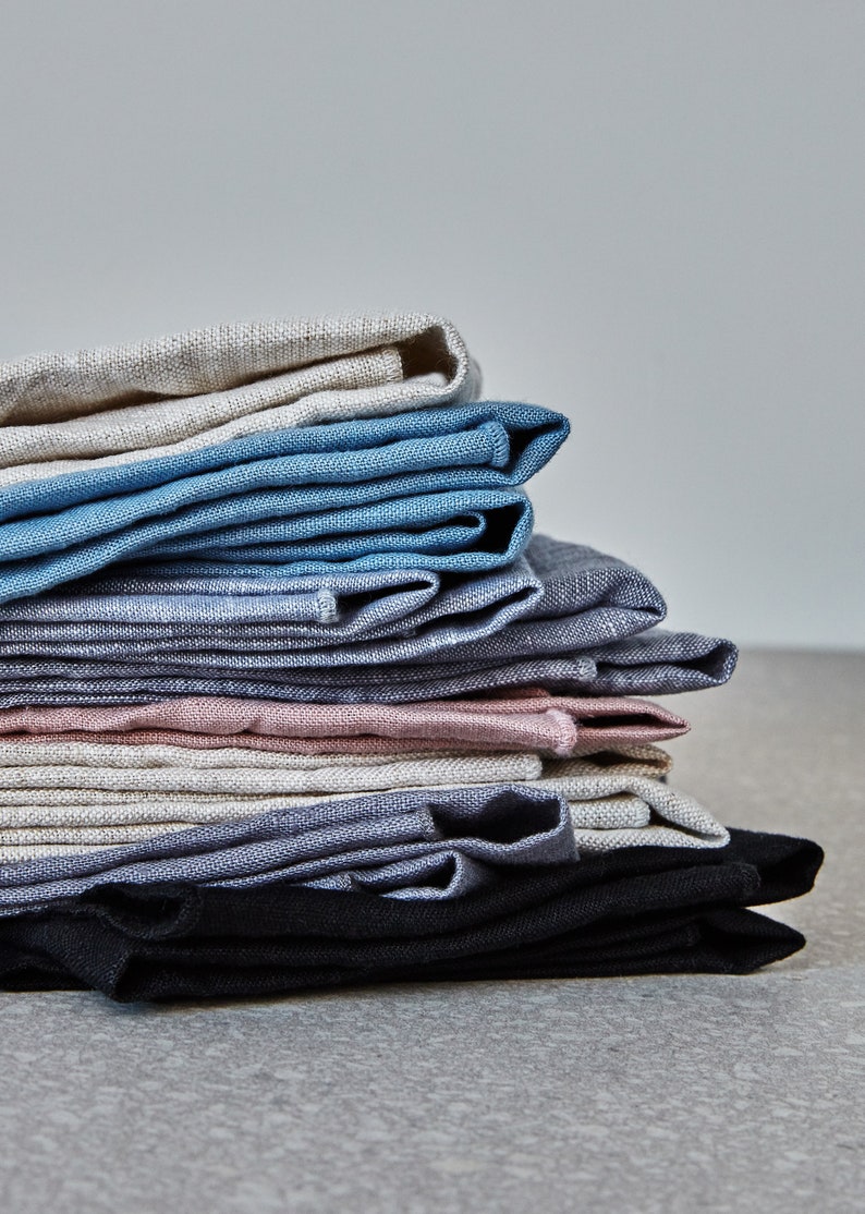 a stack of natural coloured kitchen linens on a grey surface