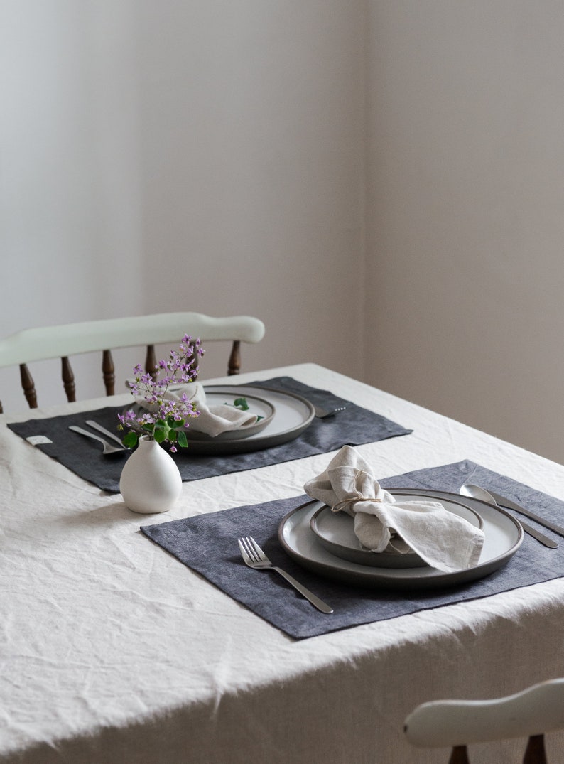 a set of two placemats on a table with napkins and flowers