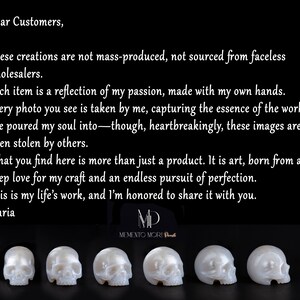 May include: Four white, hand-carved skull sculptures made of polished pearl. The sculptures are arranged in a row, with the skulls facing the viewer. The text "Memento Mori" is visible below the sculptures.