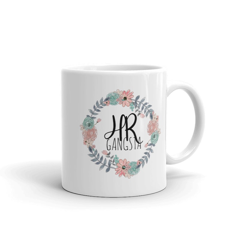 May include: White ceramic mug with a floral wreath design and the text "HR Gangsta" in black lettering.