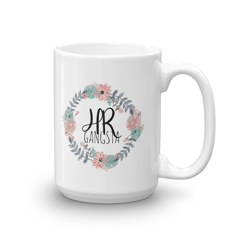 May include: White ceramic mug with a floral wreath design and the text "HR Gangsta" in black lettering.