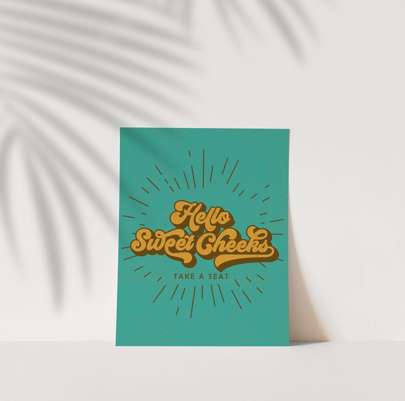Pu&ograve; includere: Un poster turchese con la scritta "Hello Sweet Cheeks, Take a Seat" in un font retr&ograve;. Il testo &egrave; in tonalit&agrave; marroni e oro, con linee radianti che emanano da dietro le parole.