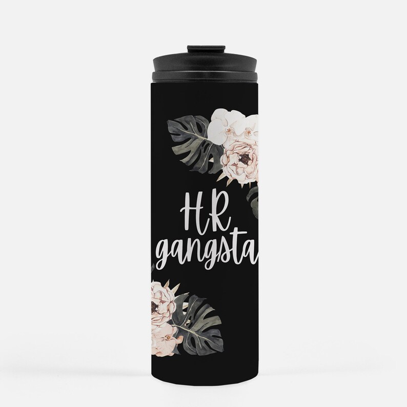 May include: Black travel mug with a black lid. The mug features the text "HR gangsta" in white script, along with floral and leaf accents in shades of white, pink, and green. The mug is designed to keep beverages hot or cold.