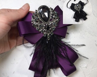 Purple brooch with feather.