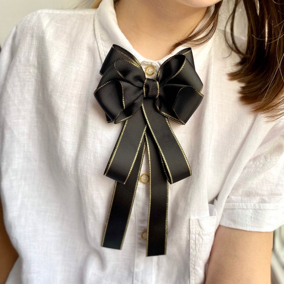 Black bow brooch deals