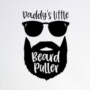 May include: Black and white graphic design of a face with sunglasses and a beard. The text "Daddy's little Beard Puller" is written below the face.