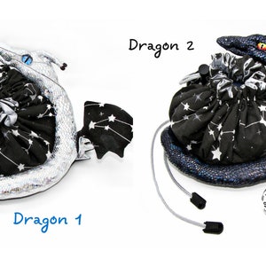 Op de afbeelding: Twee zwarte en witte trekkoordtassen met een stervormig patroon en een draakvormige stof rond de bodem. E&eacute;n draak is zilver en de andere is blauw. De tekst "Dragon 1" en "Dragon 2" staat onder elke tas.