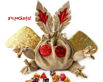 May include: A brown plush dice bag with red felt wings and red felt accents. The bag has eight pockets and is filled with colorful dice. The text "8+1 pockets!" is written in red on a white background.