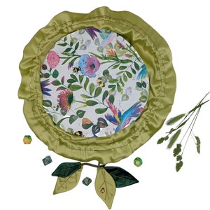 Puede incluir: Una bandeja de dados de fieltro verde con estampado floral y borde de sat&eacute;n verde. La bandeja est&aacute; rodeada de dados verdes y un par de hojas de fieltro verde.