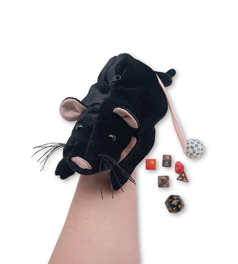 Pu&ograve; includere: Borsa da gioco in peluche nera a forma di topo con chiusura a zip e coda rosa. La borsa contiene una variet&agrave; di dadi, tra cui un d20, d12, d10, d8, d6 e un d4.