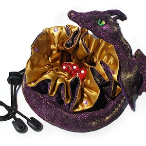 May include: Purple and gold dragon-shaped dice bag with a drawstring closure. The bag is filled with red dice.