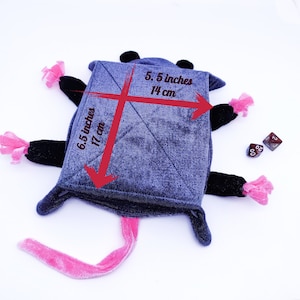 May include: A grey plush rat toy with pink and black accents. The toy is 17 cm tall and 14 cm wide. It has a long pink tail and two dice are lying next to it.