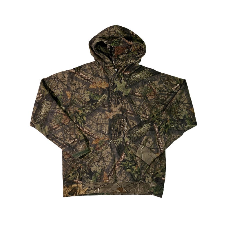 May include: A green, brown and black camouflage hoodie with a drawstring hood.