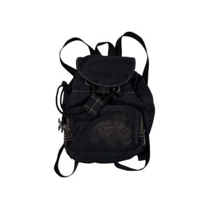 Pode incluir: Mochila mini preta com fecho de cordão e um pequeno desenho bordado na frente.