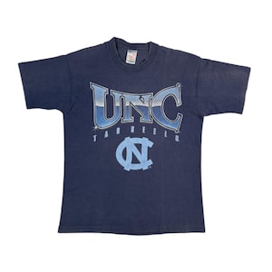 May include: A vintage navy blue t-shirt with a faded blue and white graphic of "UNC Tarheels" with a large Carolina blue "N" logo.