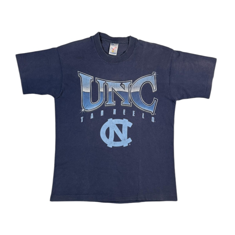 May include: A vintage navy blue t-shirt with a faded blue and white graphic of "UNC Tarheels" with a large Carolina blue "N" logo.