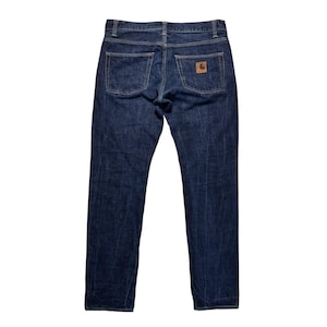 Puede incluir: Vaqueros de mezclilla azul oscuro con un dise&ntilde;o cl&aacute;sico de cinco bolsillos. Los vaqueros tienen un corte de pierna recta y un parche de cuero marr&oacute;n en el bolsillo trasero. Los vaqueros est&aacute;n hechos de un material de mezclilla duradero.