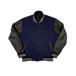 May include: A navy blue varsity jacket with black leather sleeves and white striped trim. The jacket has a button closure and two pockets.