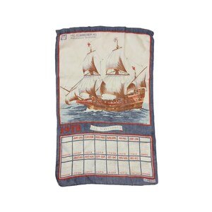 Puede incluir: Una toalla de cocina azul y blanca con un calendario para 1978 y una ilustraci&oacute;n del barco Mayflower. El texto "HIC SUMMERER AG" y "800208 101" est&aacute; impreso en la toalla.