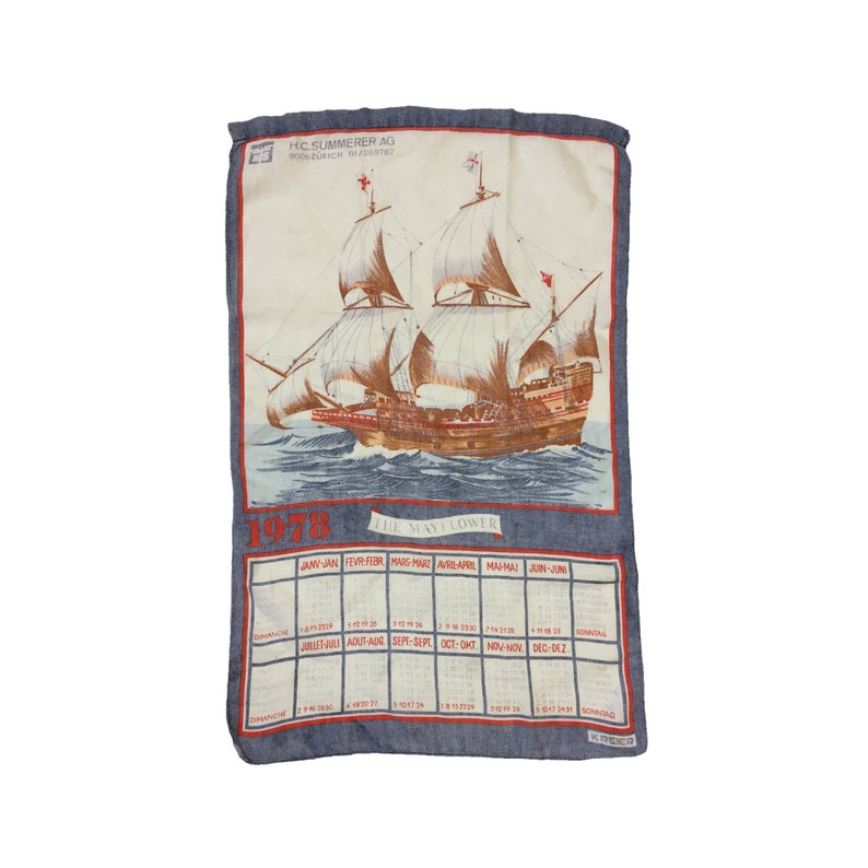 Puede incluir: Una toalla de cocina azul y blanca con un calendario para 1978 y una ilustraci&oacute;n del barco Mayflower. El texto "HIC SUMMERER AG" y "800208 101" est&aacute; impreso en la toalla.