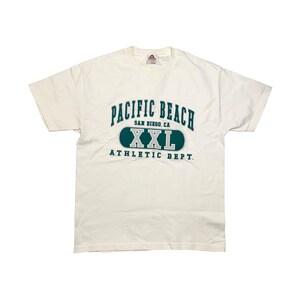 May include: White t-shirt with a green and blue graphic that says "Pacific Beach, San Diego, CA, XXL, Athletic Dept."