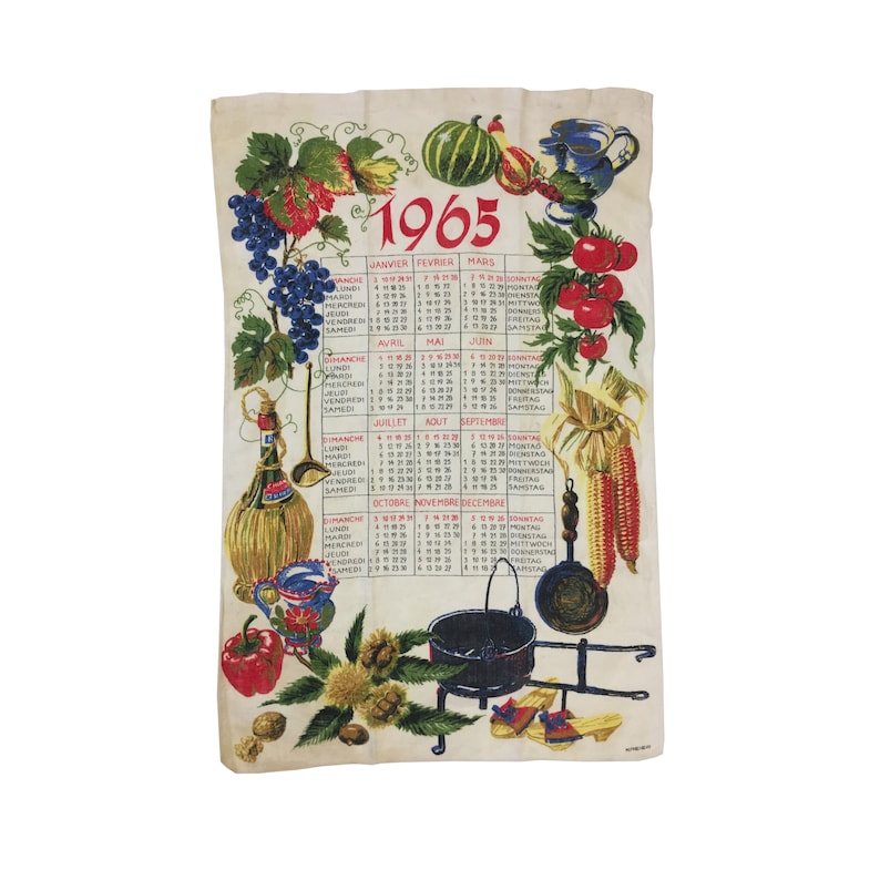 Puede incluir: Una toalla de cocina vintage con un dise&ntilde;o de calendario de 1965. La toalla presenta una ilustraci&oacute;n colorida de frutas, verduras y utensilios de cocina. El calendario est&aacute; en franc&eacute;s e incluye los meses de enero a diciembre.