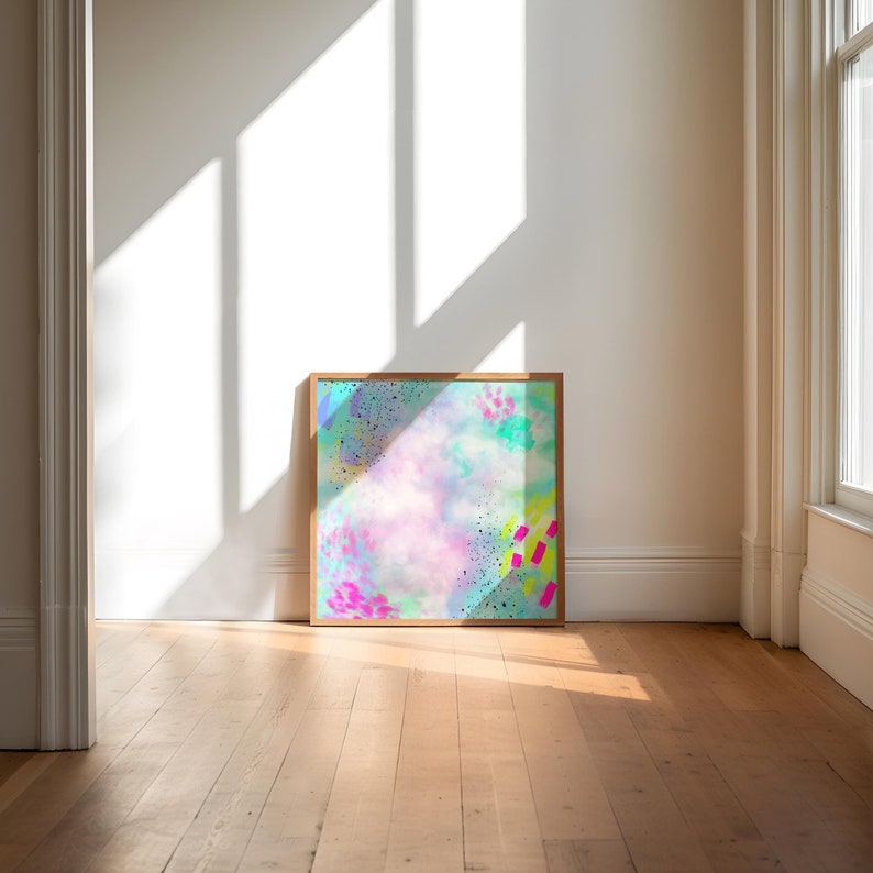 May include: A framed abstract painting with a light blue, pink, and green background. The painting has a variety of colorful shapes and splatters of paint.