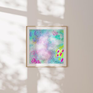 May include: Abstract art print with a colorful, layered design featuring pink, blue, green, yellow, and black paint splatters and brushstrokes. The print is framed in a light wood frame.