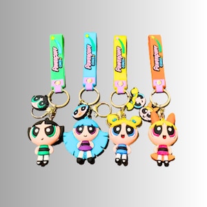 May include: Four Powerpuff Girls keychains with colorful straps. Each keychain features a different Powerpuff Girl character: Bubbles, Buttercup, Blossom, and Mojo Jojo. The straps are labeled "Powerpuff Girls".