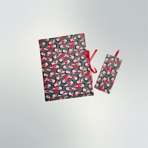 May include: A gray book cover with a red ribbon and a matching bookmark. The cover and bookmark are printed with a repeating pattern of cartoon women in red dresses.