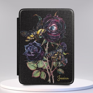 May include: A black e-reader case featuring a detailed illustration of two dark purple roses, one with a human eye in the center, and two moths with skull markings on their backs. The name Jessica is printed in gold cursive script at the bottom right.
