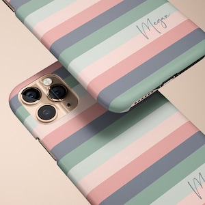 May include: Two phone cases with a striped pattern in shades of pink, blue, and green. The cases have the name "Megan" written on them in a cursive font.