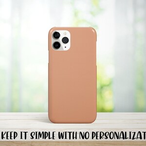 May include: A peach-colored phone case for an iPhone with a camera bump and three lenses.