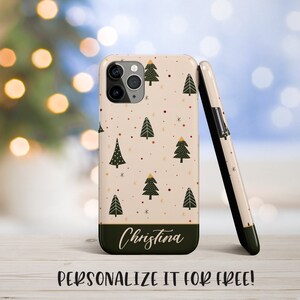 K&ouml;nnte beinhalten: Eine personalisierte Handyh&uuml;lle mit cremefarbenem Hintergrund und einem Muster aus gr&uuml;nen Weihnachtsb&auml;umen, roten und goldenen Punkten und Schneeflocken. Der Text "Christina" ist in Schwarz am unteren Rand der H&uuml;lle aufgedruckt.