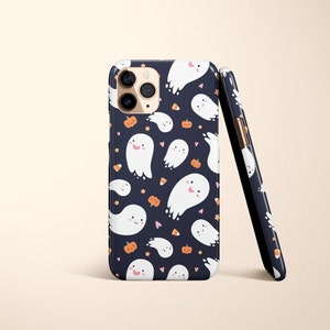 May include: A black phone case with a white ghost and pumpkin pattern. The case has a camera cutout and a gold trim.