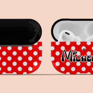 May include: Red and white polka dot Airpods case with a black  "Michelle" name on the front. The case has a black top and a silver keychain.