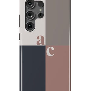 May include: A phone case with a geometric design featuring a white, gray, dark blue, and pink color scheme. The case has a cutout for the camera lens and the letters "a" and "c" are printed on the case.