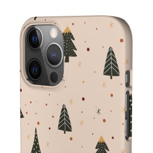 K&ouml;nnte beinhalten: Eine beige iPhone-H&uuml;lle mit einem sich wiederholenden Muster aus stilisierten Weihnachtsb&auml;umen, Schneeflocken und roten und orangefarbenen Punkten.